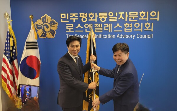 이용태 21기 회장(오른쪽)이 장병우 22기 회장에게 LA평통 깃발을 넘겨주고 있다. @LA우리방송